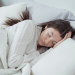 Een persoon slaapt op een ergonomisch hoofdkussen voor optimale slaaphouding en comfort.
