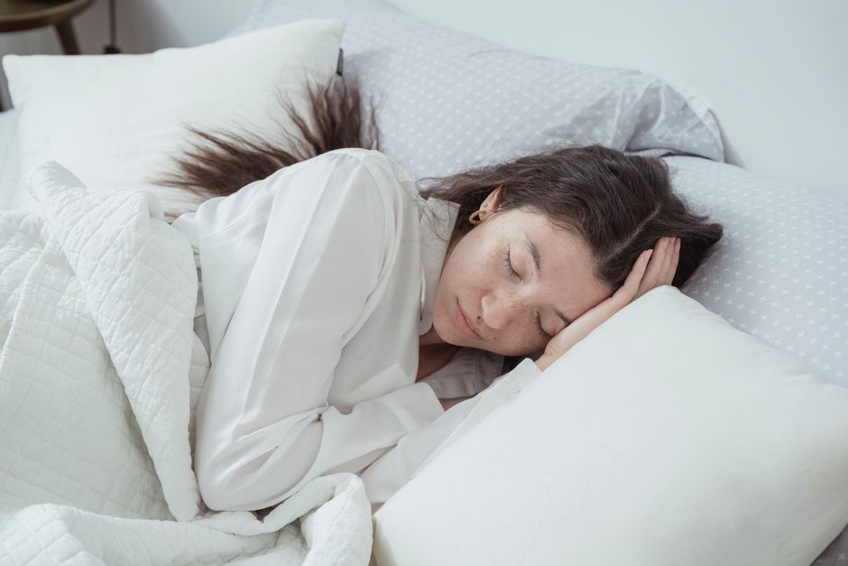 Een persoon slaapt op een ergonomisch hoofdkussen voor optimale slaaphouding en comfort.